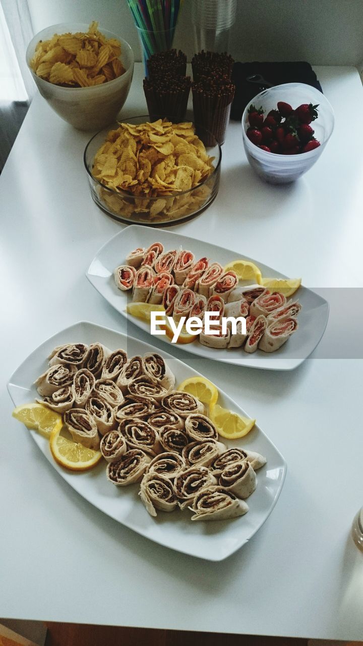 Directly above shot of serving wrap sandwich with chips on table