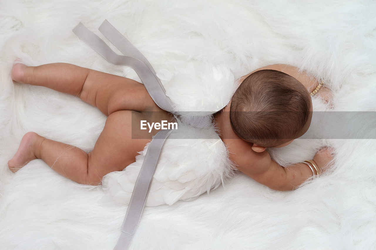 High angle view of baby boy lying on fur bed