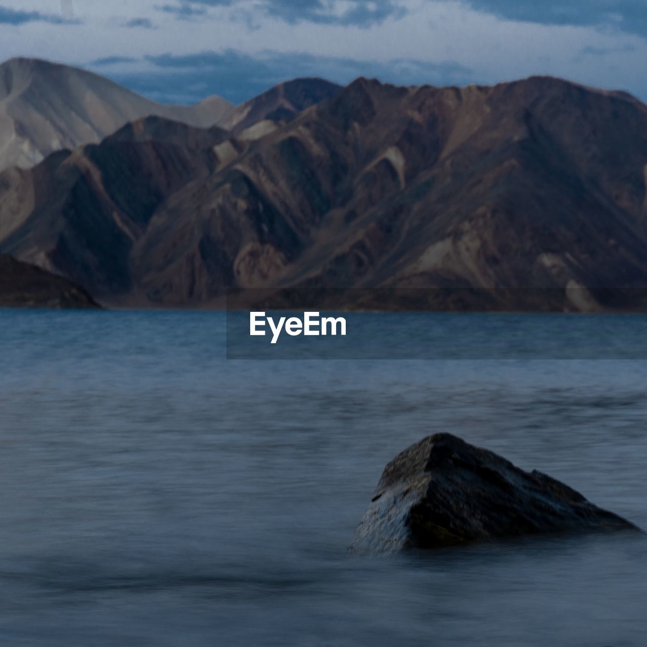 SCENIC VIEW OF SEA BY MOUNTAINS AGAINST SKY