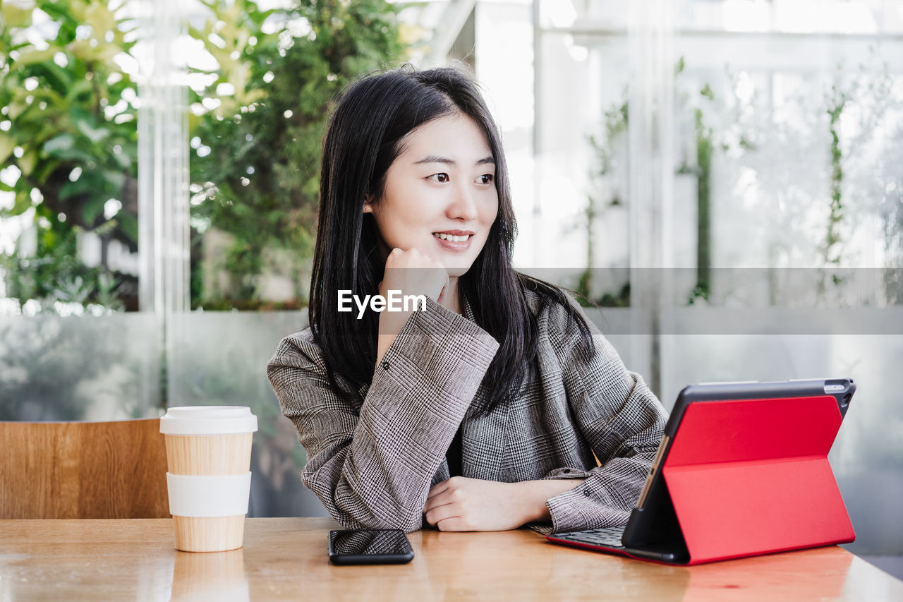 Professional chinese entrepreneur woman working on laptop in cafeteria. technology, lifestyle