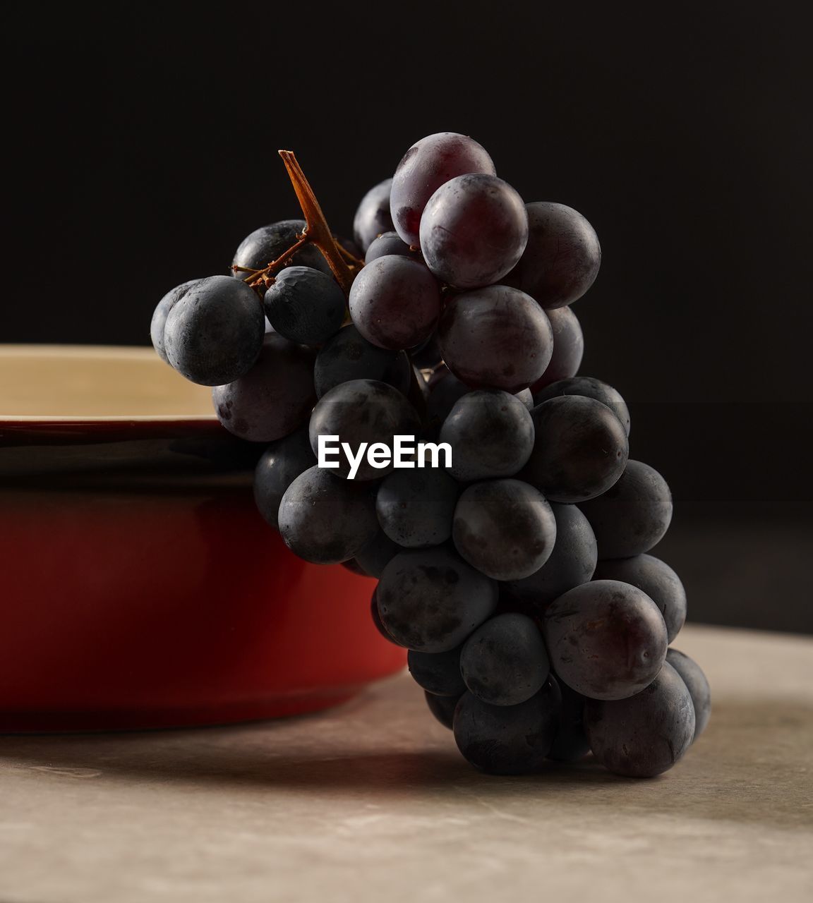 Close-up of grapes on table against black background