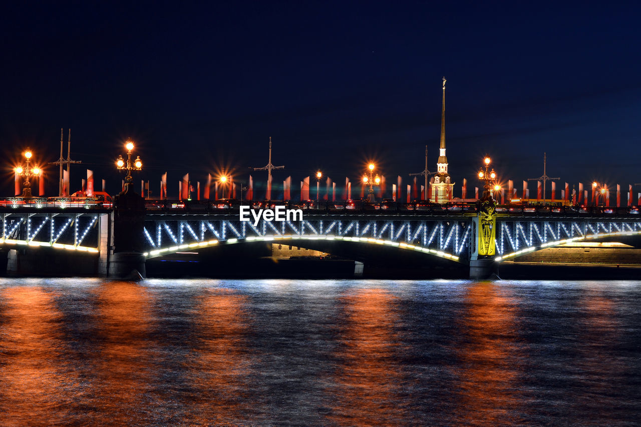 Illuminated trinity bridge over neva river against sky at night