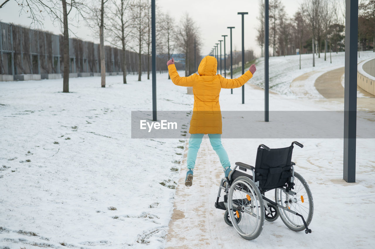 Happy caucasian woman got up from the wheelchair and jumping. happy girl recovers and starts walking