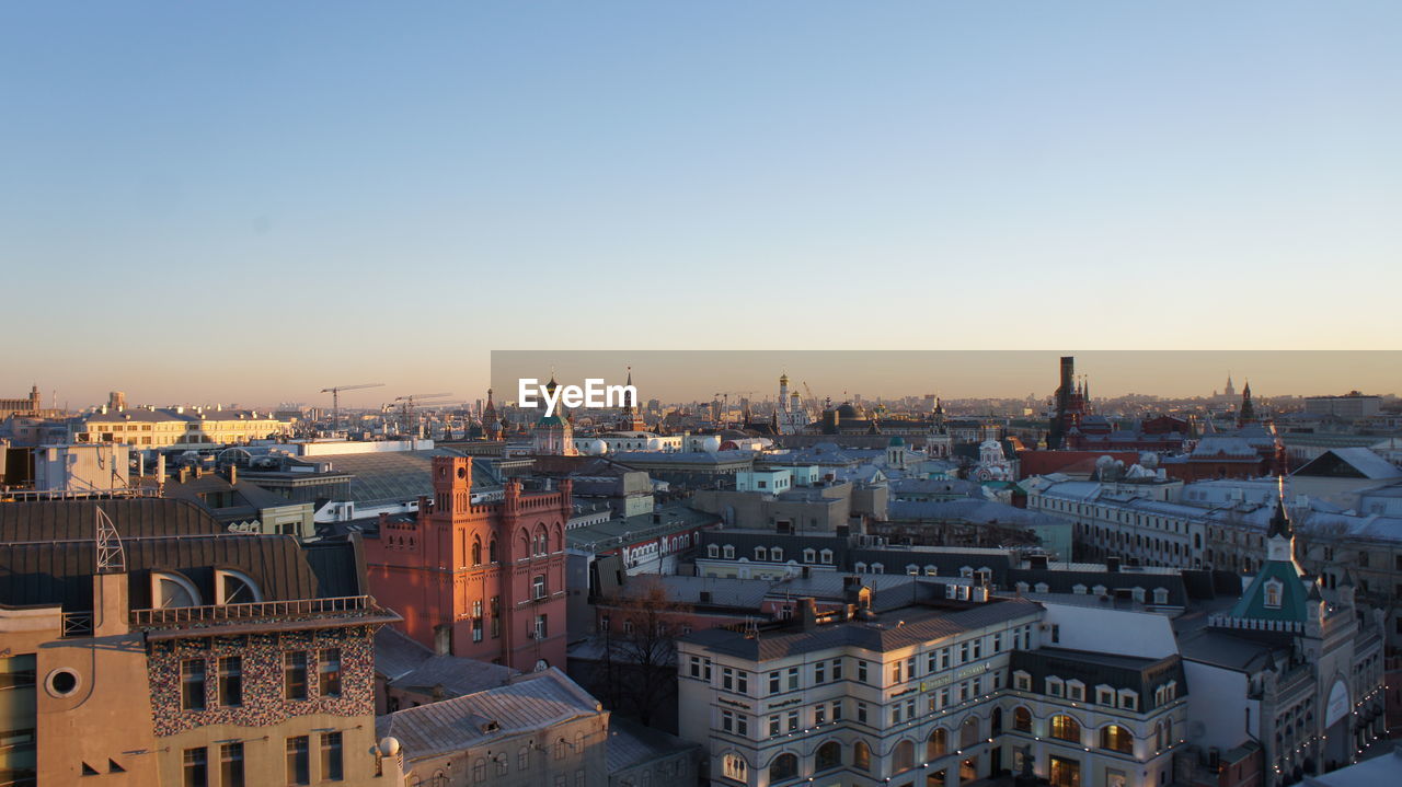 HIGH ANGLE VIEW OF CITY AGAINST SKY DURING SUNSET