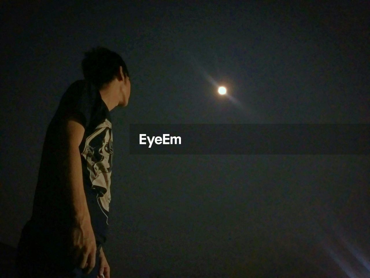 Low angle view of man looking at moon