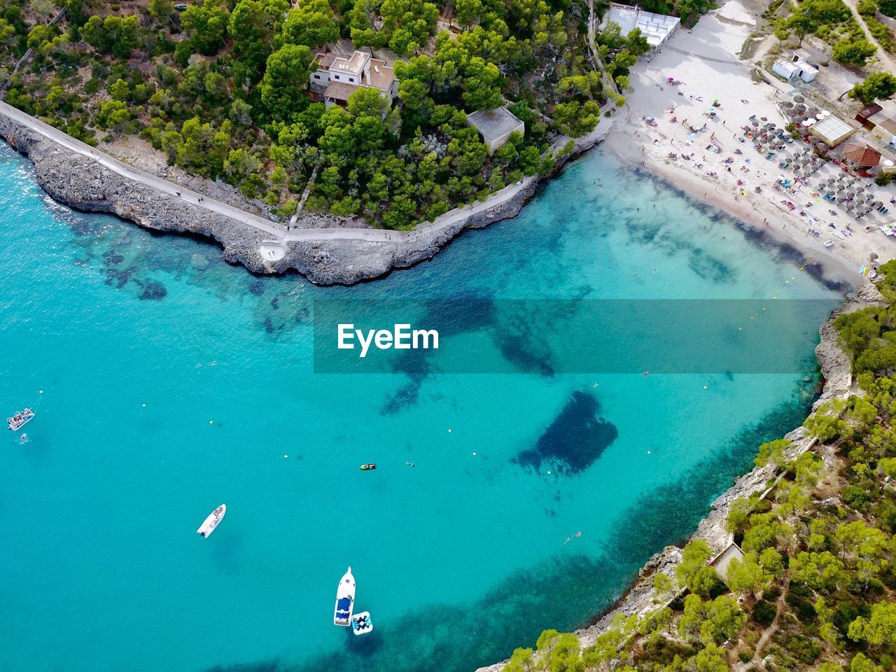 HIGH ANGLE VIEW OF PEOPLE SWIMMING ON BEACH