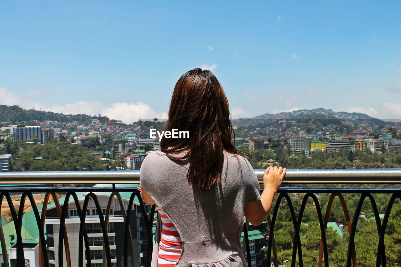Rear view of woman looking at cityscape