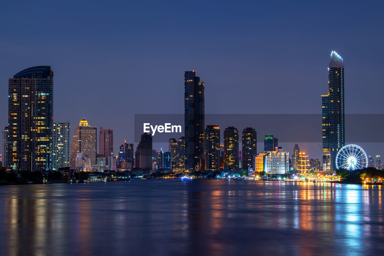 ILLUMINATED MODERN BUILDINGS IN CITY AT NIGHT