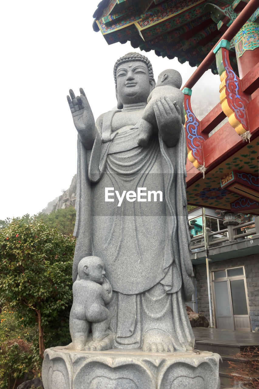 LOW ANGLE VIEW OF STATUE AGAINST TREES