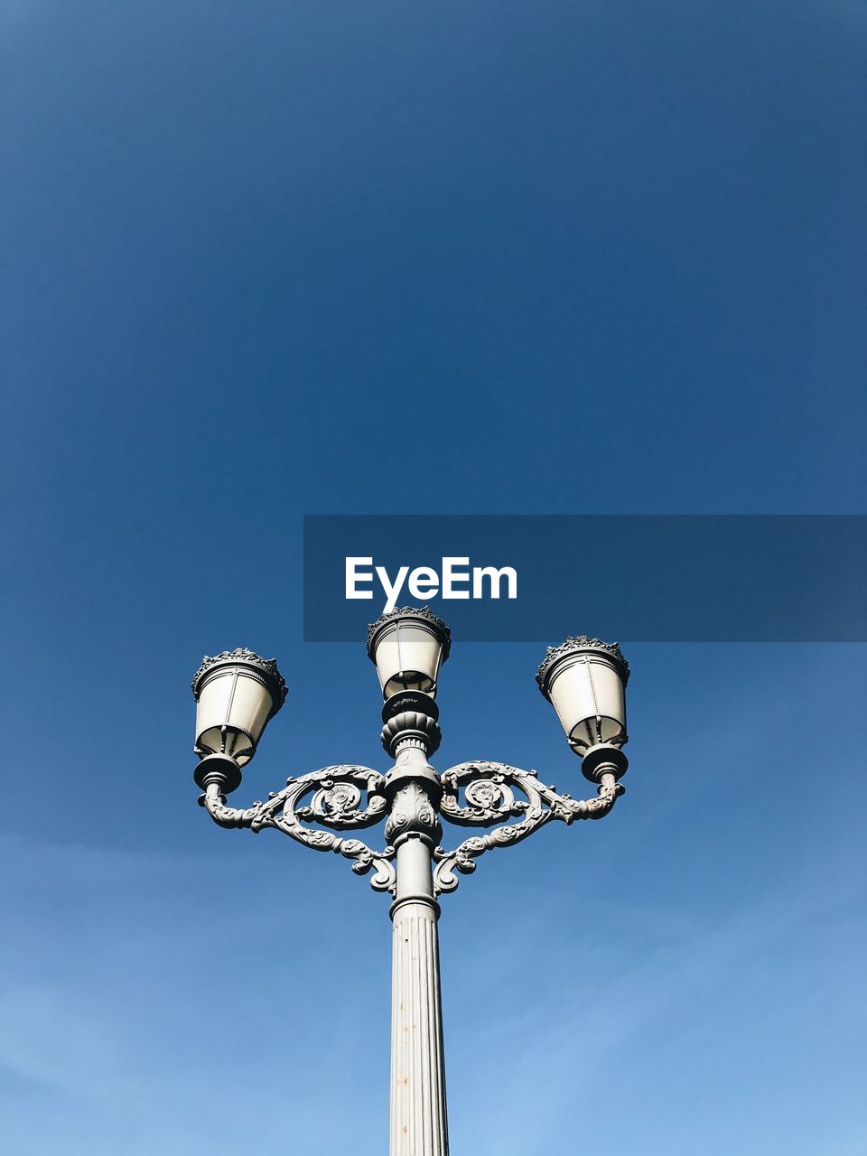 LOW ANGLE VIEW OF STREET LIGHTS AGAINST BLUE SKY