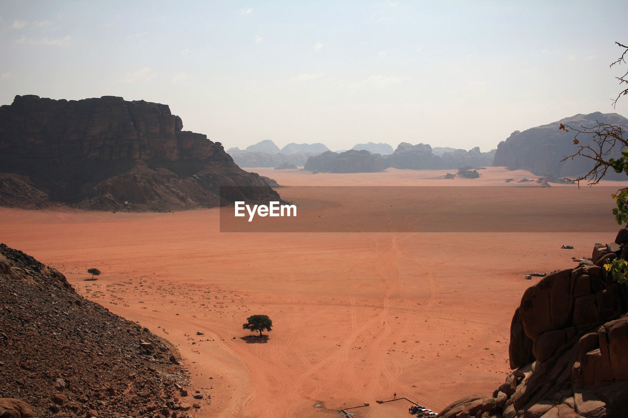 landscape, natural environment, environment, land, scenics - nature, sky, nature, wadi, desert, beauty in nature, travel, rock, travel destinations, sand, mountain, valley, sunlight, sunset, tranquility, sand dune, climate, no people, cloud, outdoors, non-urban scene, tourism, arid climate, plateau, sun, wilderness, erg, clear sky, sunny, tranquil scene, water, day, dry, rock formation, adventure, animal wildlife, semi-arid