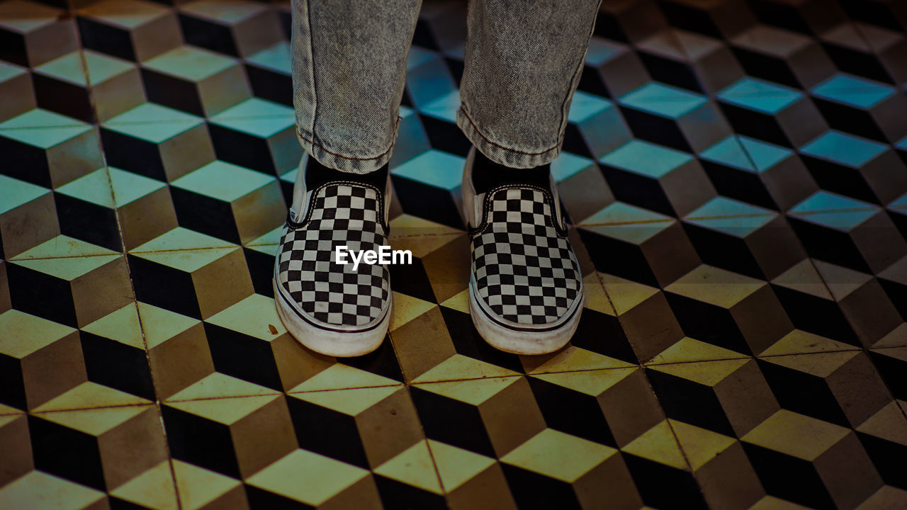 Low section of man standing on tiled floor