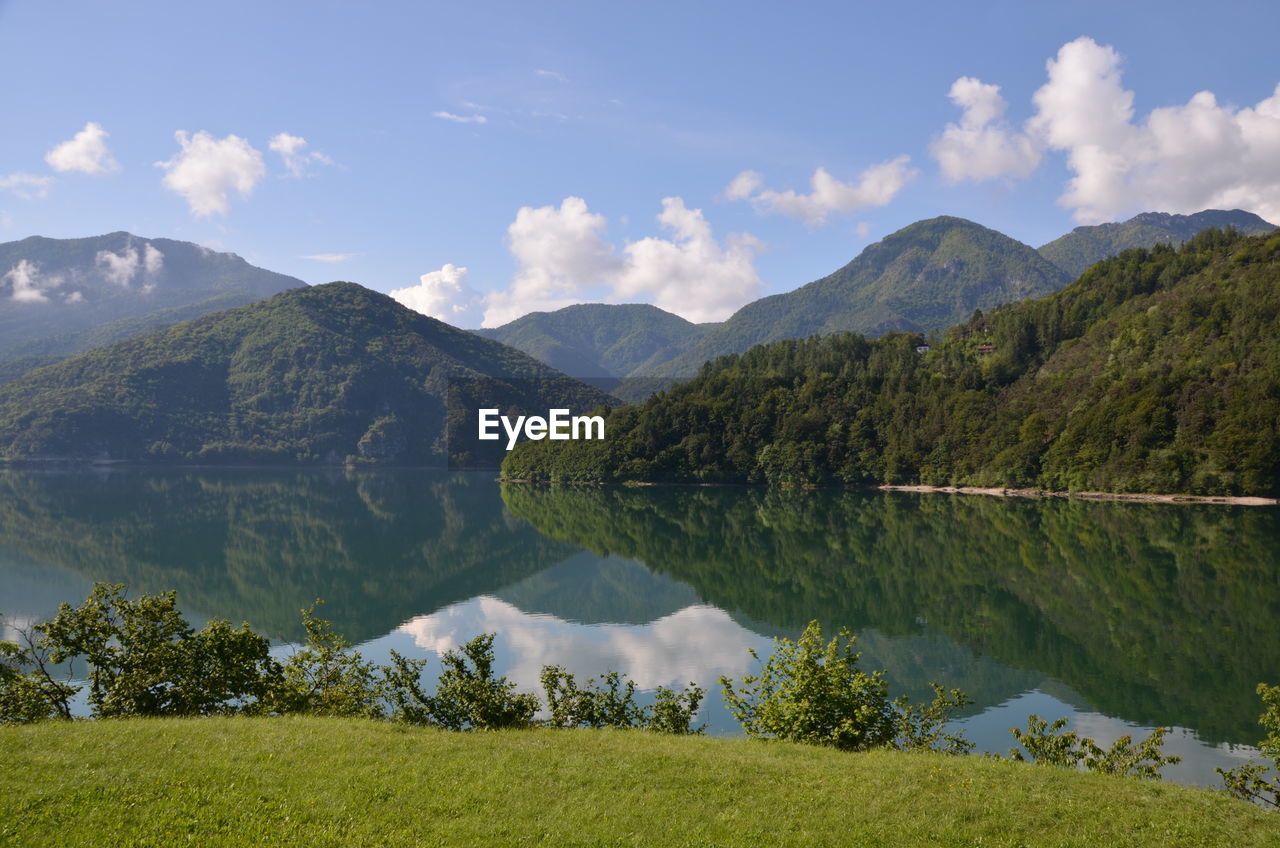 Reflection of lush mountains in calm lake