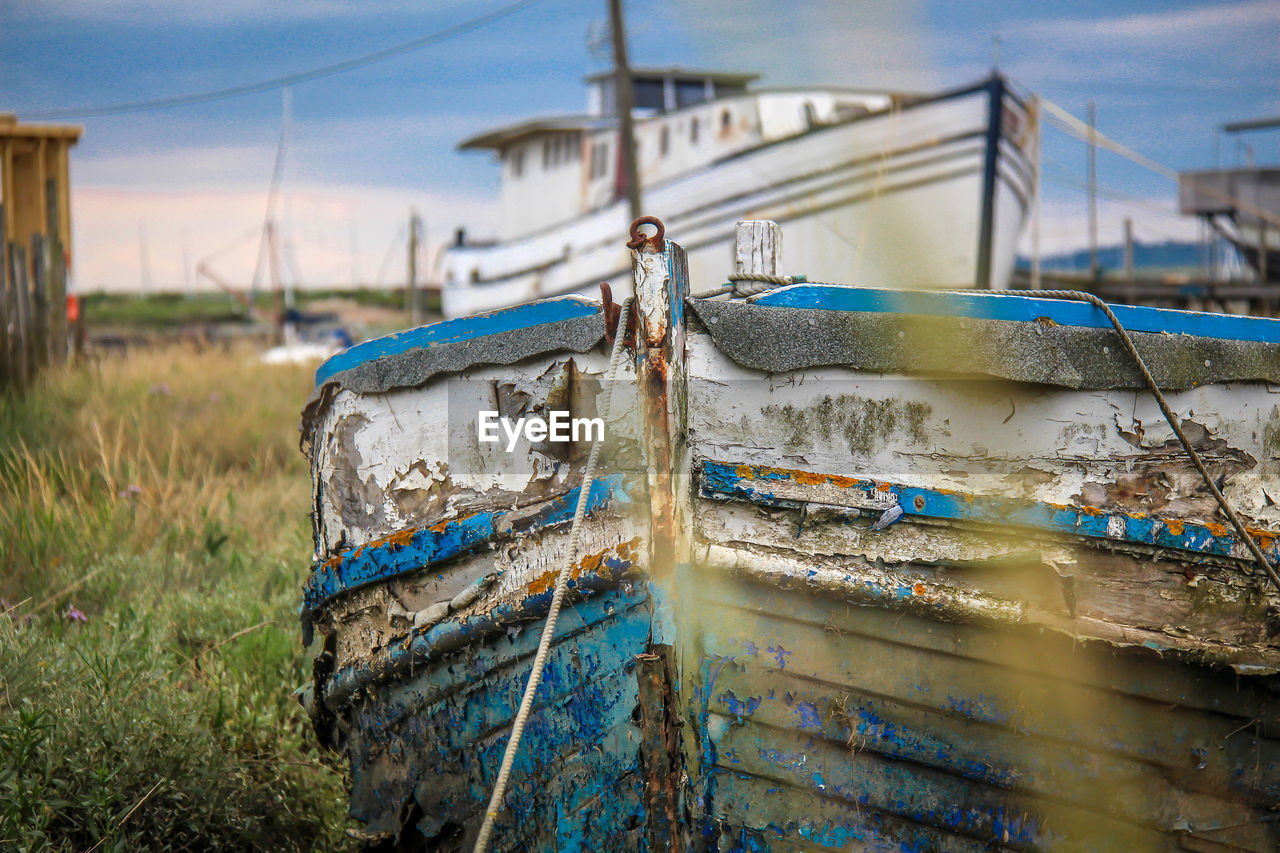 Boats moored on grassy field