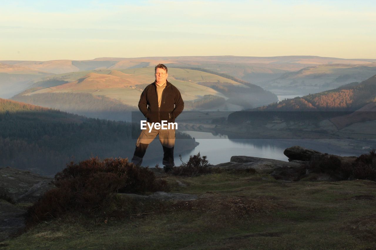 Portrait of man standing on mountain against sky