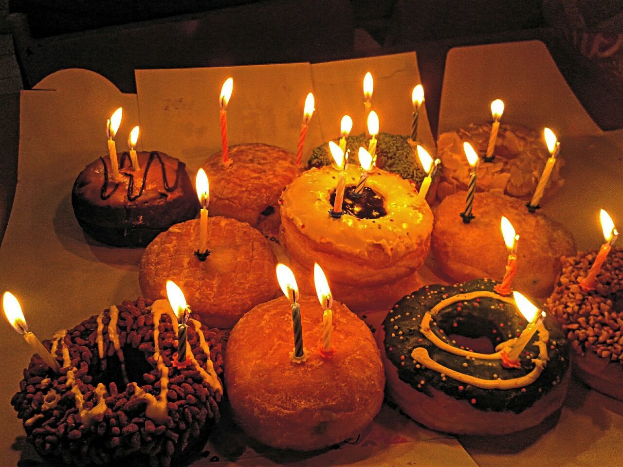 CLOSE-UP OF LIT CANDLES ON TABLE