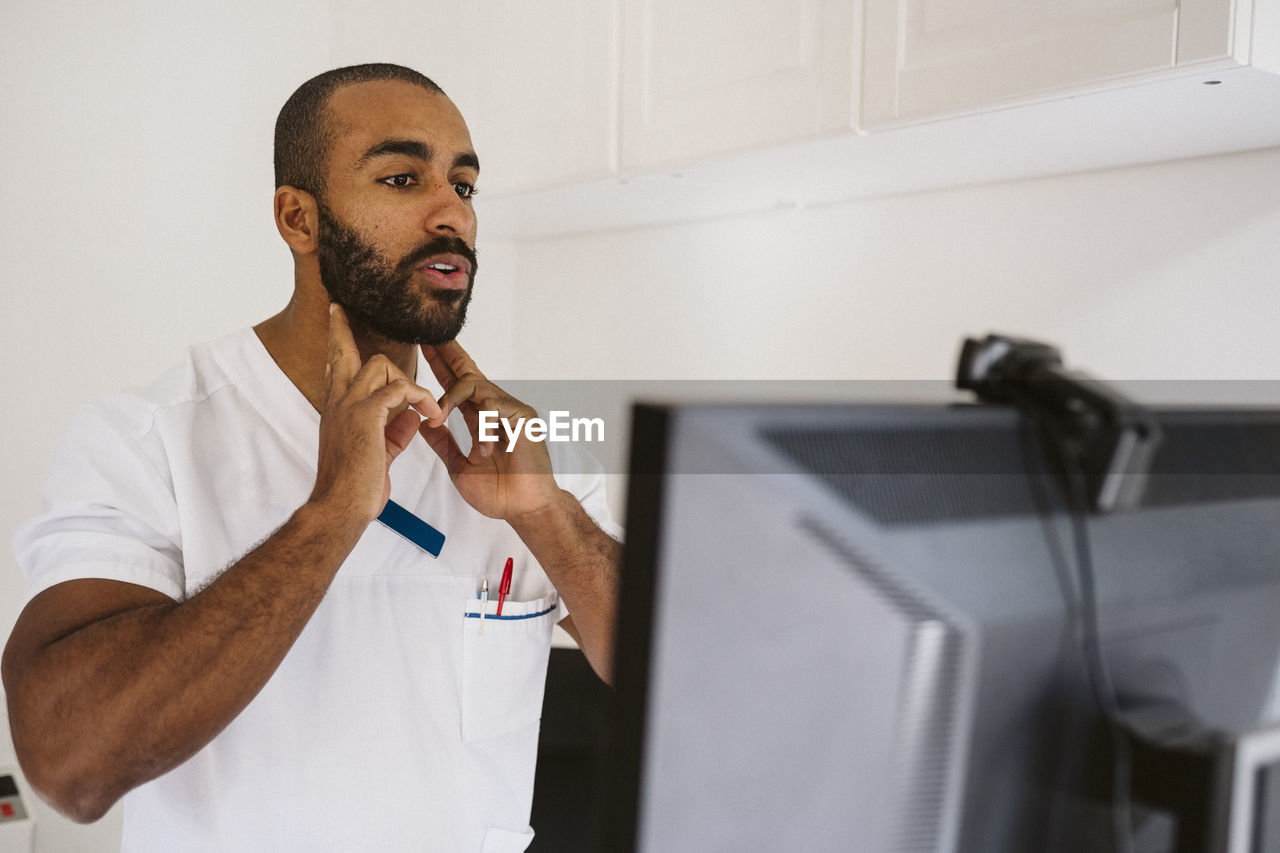 Male doctor consulting through video call at medical clinic