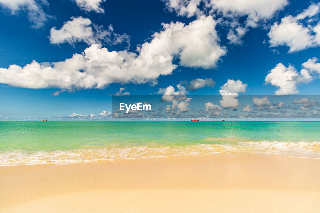sky, sea, water, land, beach, cloud, scenics - nature, beauty in nature, nature, travel, horizon, environment, travel destinations, blue, tropical climate, sand, holiday, tranquility, trip, vacation, landscape, body of water, horizon over water, summer, tourism, shore, wave, idyllic, ocean, tranquil scene, turquoise colored, wind wave, outdoors, cloudscape, water's edge, no people, sunlight, island, lagoon, day, backgrounds, motion, seascape, coastline, sun, urban skyline, sunny, relaxation, coast, copy space
