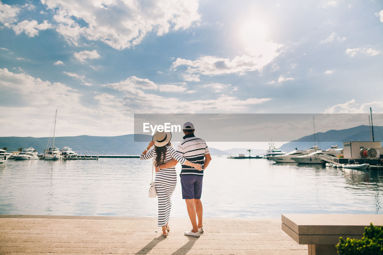 Rear view of couple standing on promenade against sky