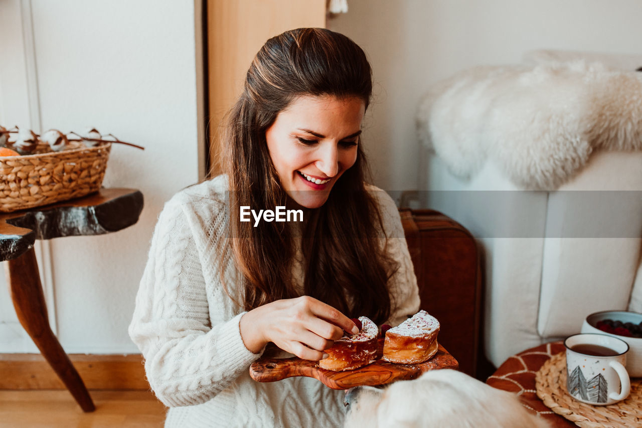 Woman eating sweet food while sitting at home