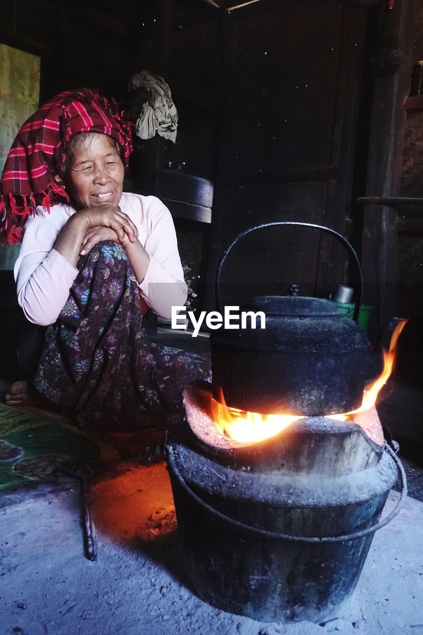 Woman preparing food on fire at home