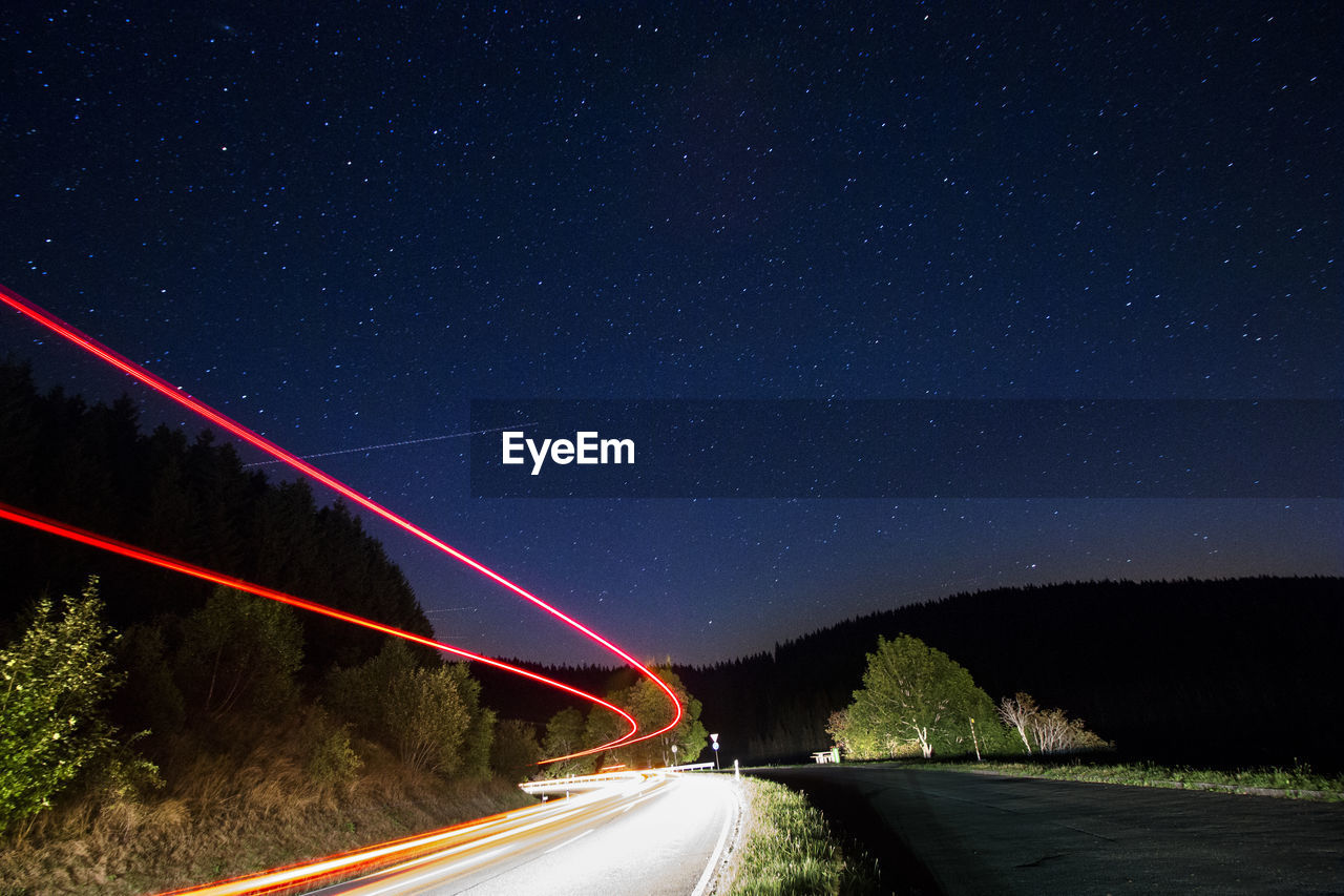 LIGHT TRAILS ON ROAD AT NIGHT