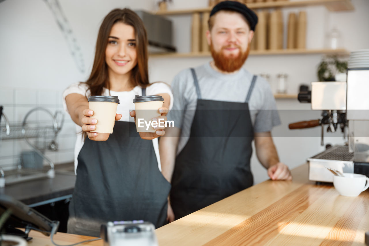 young woman using mobile phone while sitting at table