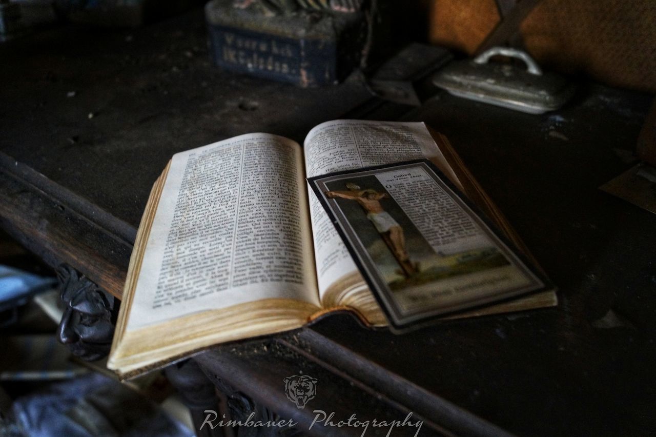 HIGH ANGLE VIEW OF TEXT ON OPEN BOOK AT TEMPLE