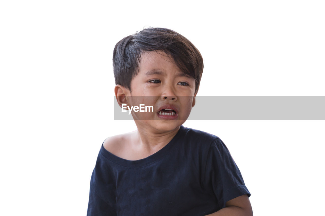 Boy crying against white background