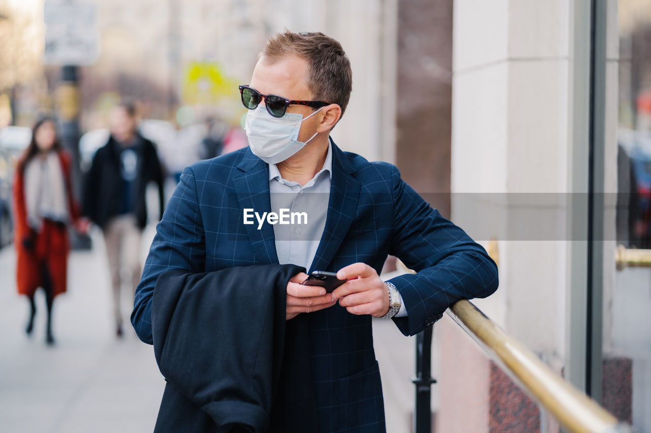 Young man wearing sunglasses while standing outdoors