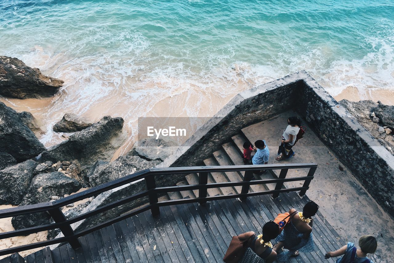 High angle view of people walking on steps by beach