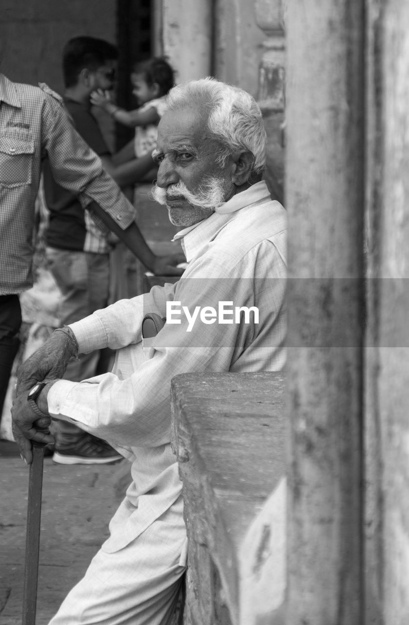 SIDE VIEW OF MAN STANDING OUTDOORS