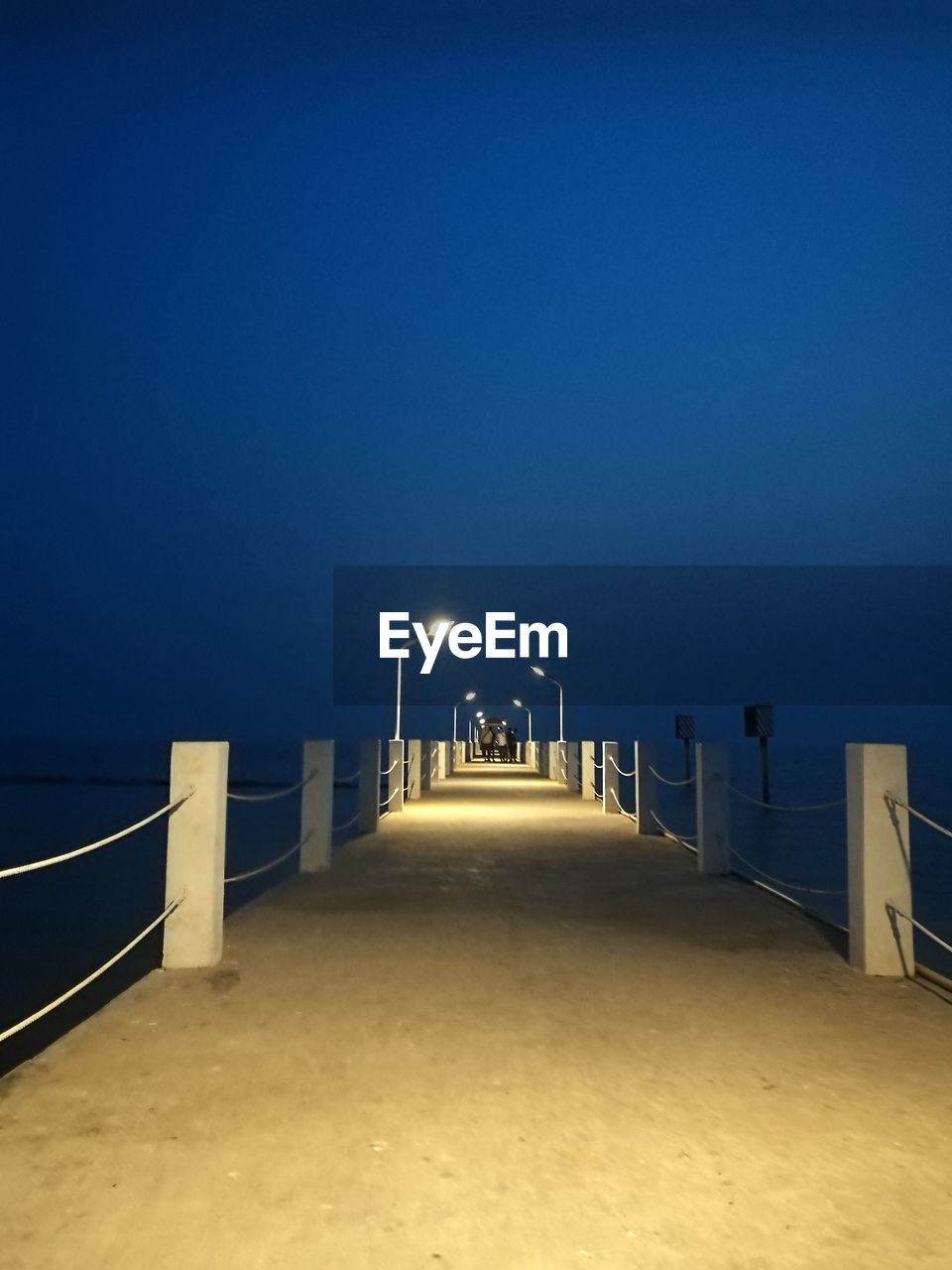 ILLUMINATED WALKWAY AGAINST CLEAR SKY AT NIGHT