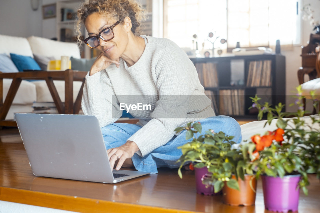 young man using laptop while sitting on table