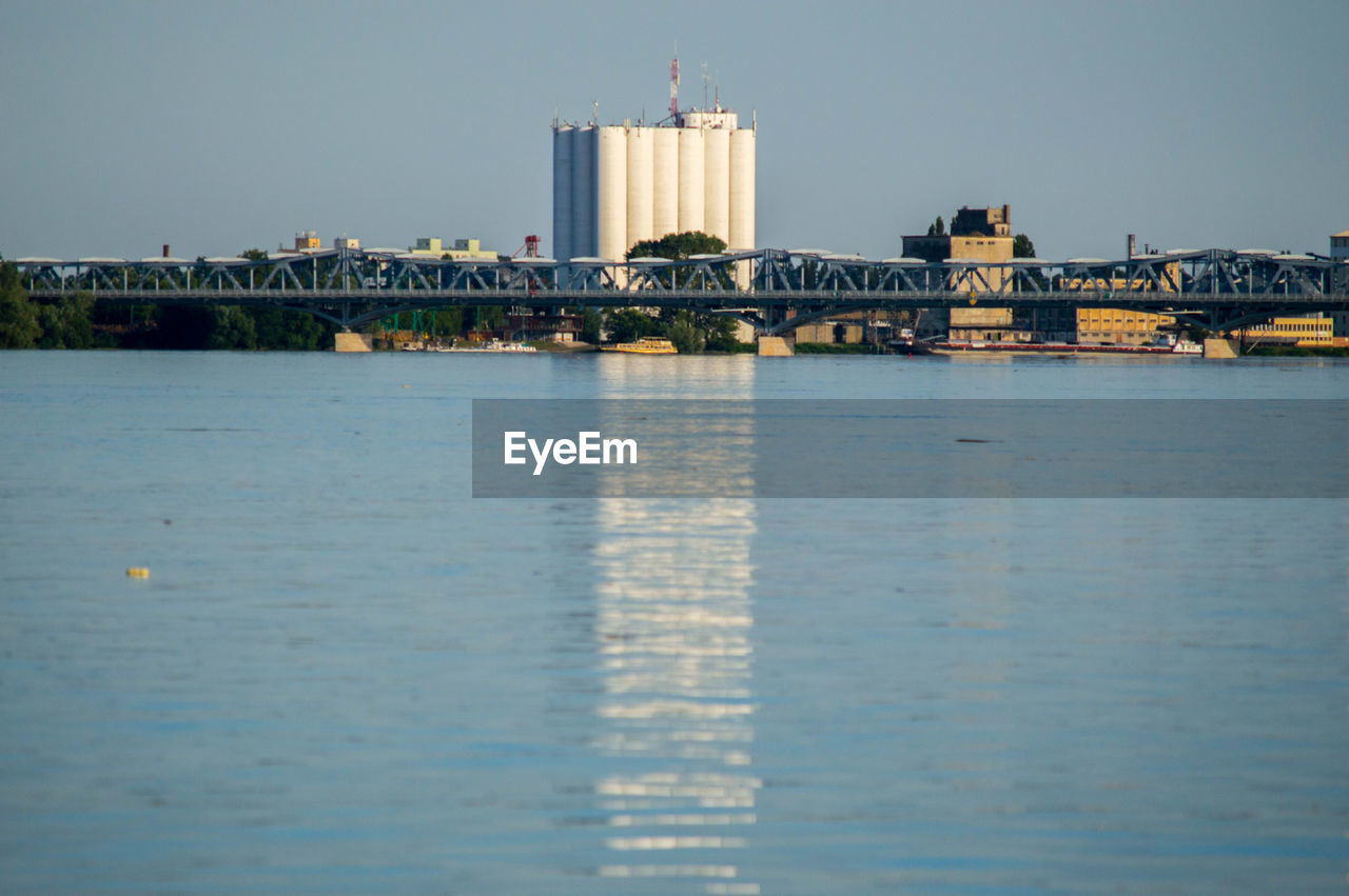 View of bridge against industrial buildings