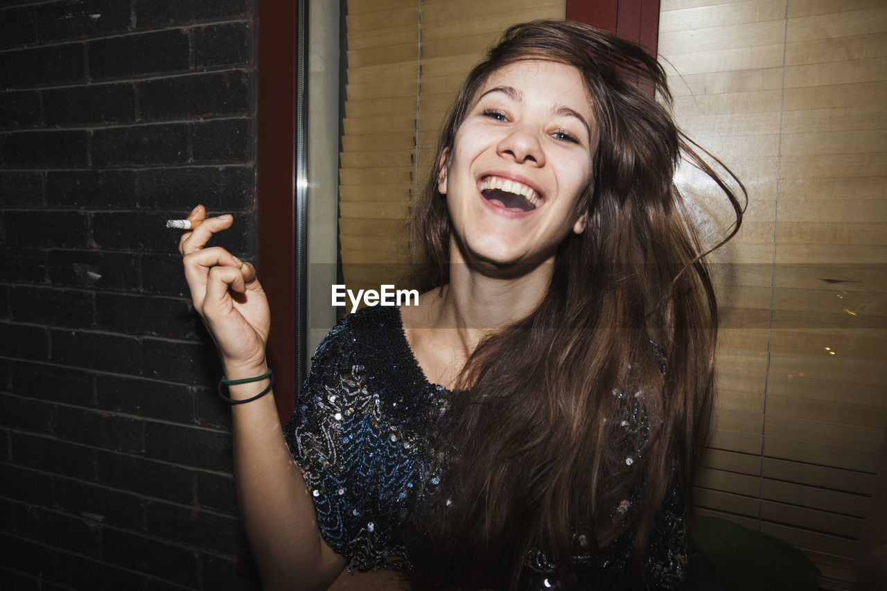 Laughing young woman smoking a cigarette