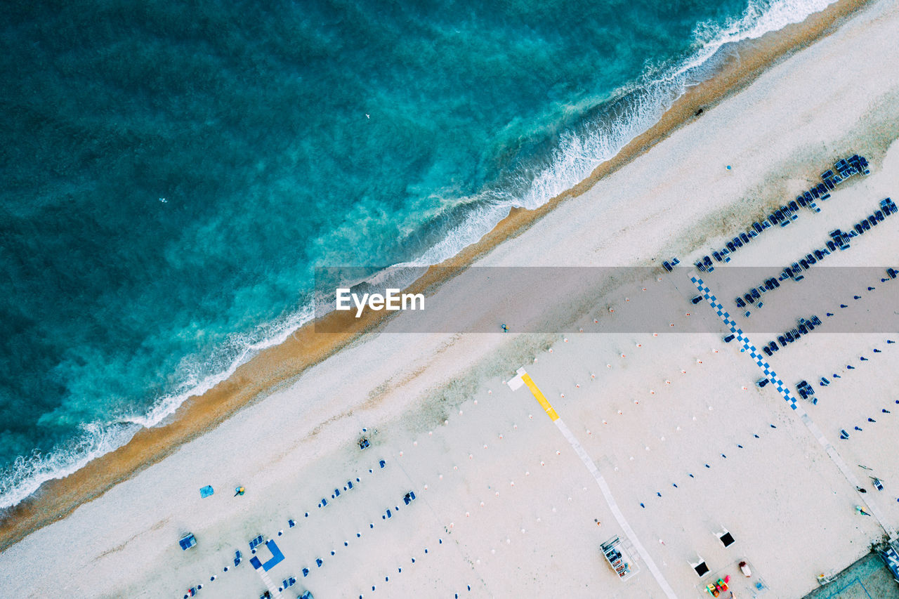 Top view of natural clear blue sea and white sand beach with umbrella