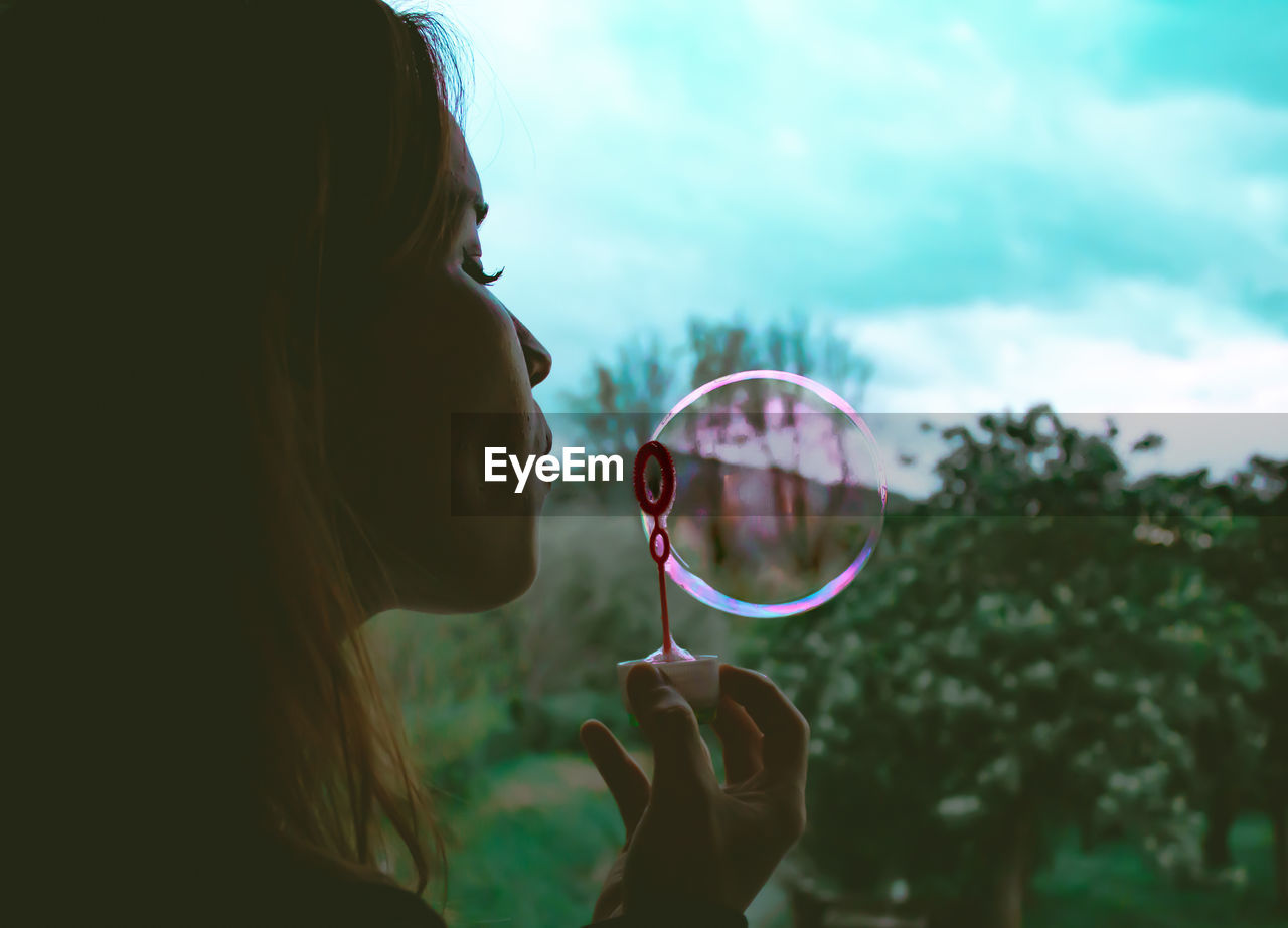 Close-up of woman blowing bubbles