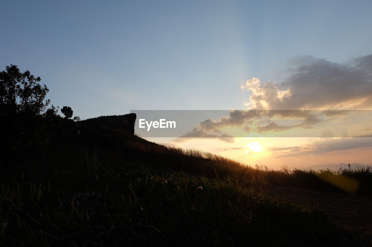 SCENIC VIEW OF SILHOUETTE FIELD AGAINST SKY AT SUNSET