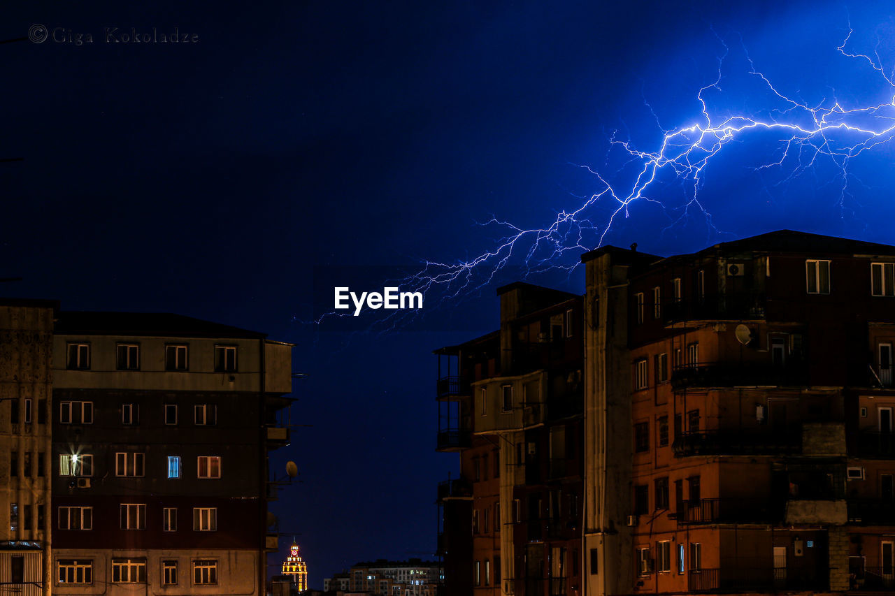 Low angle view of illuminated buildings against sky at night