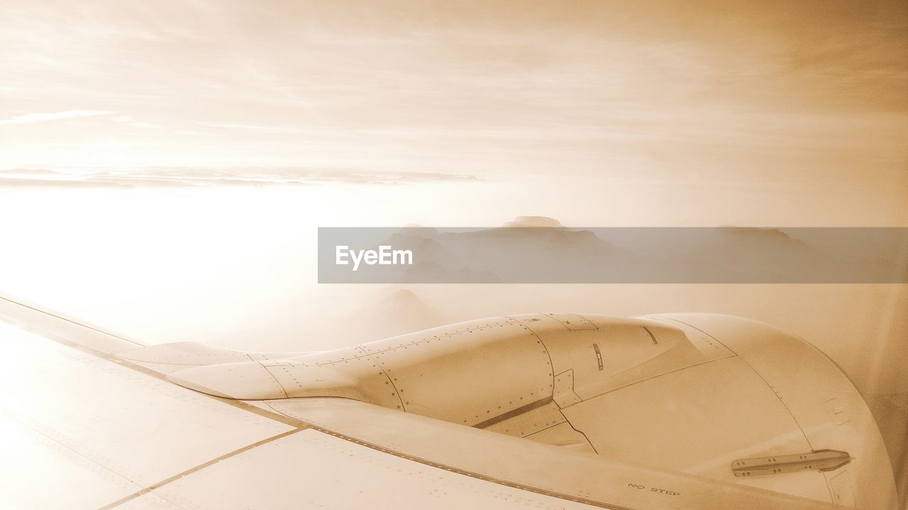 CLOSE-UP OF AIRPLANE ON LANDSCAPE AGAINST SKY