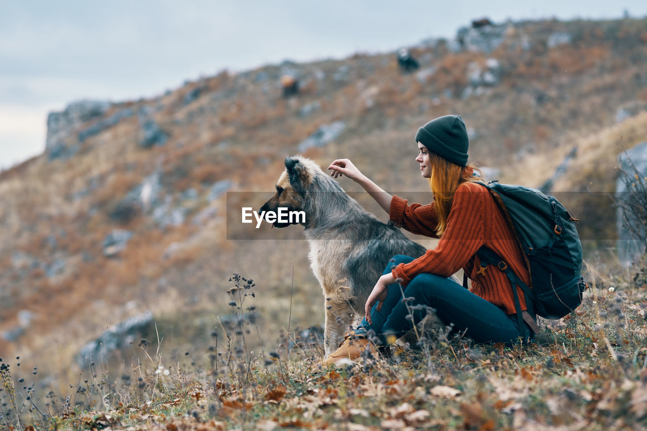 WOMAN SITTING WITH DOG ON STREET