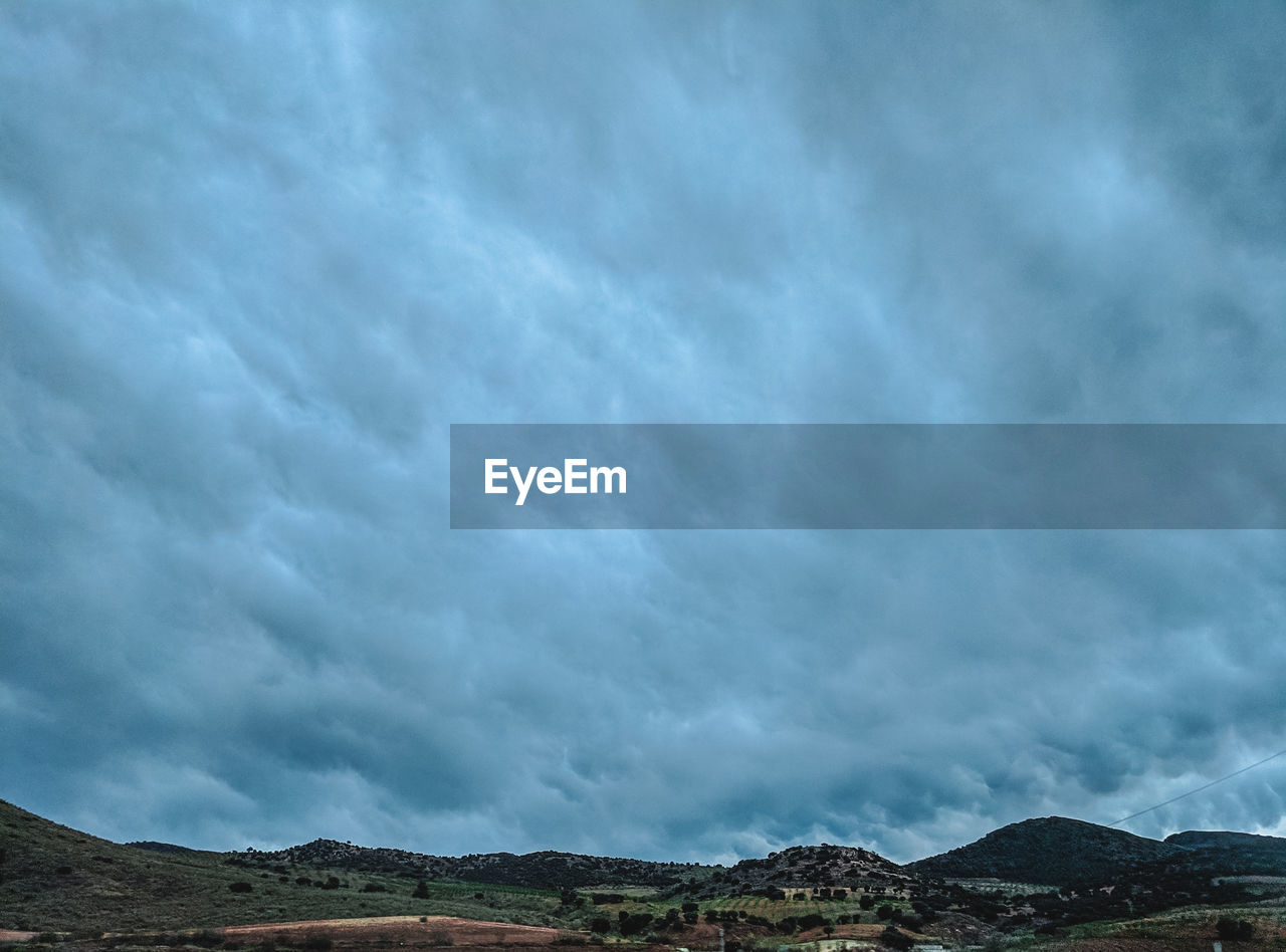 Scenic view of mountain against cloudy sky