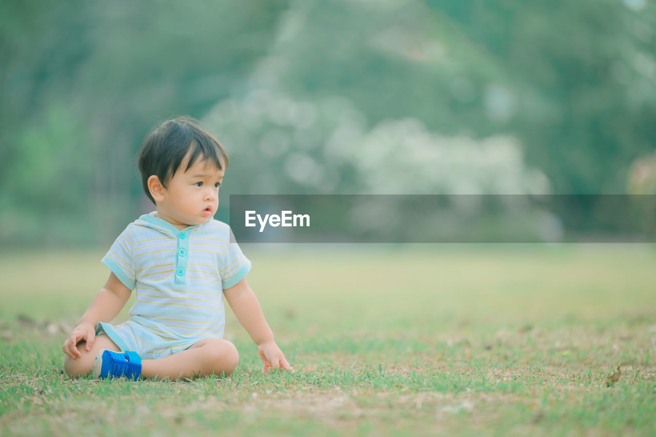 Cute boy looking away on field