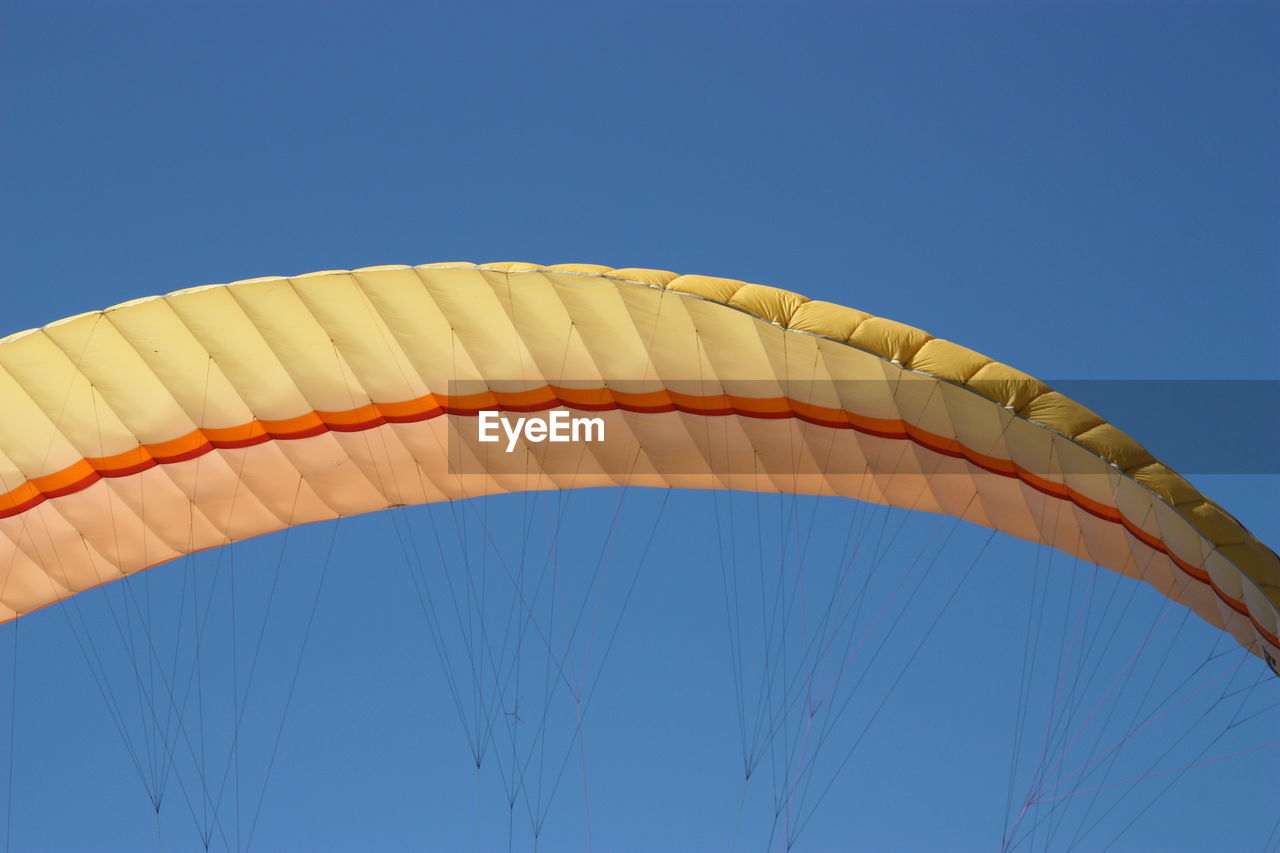 Low angle close-up of parachute against clear blue sky