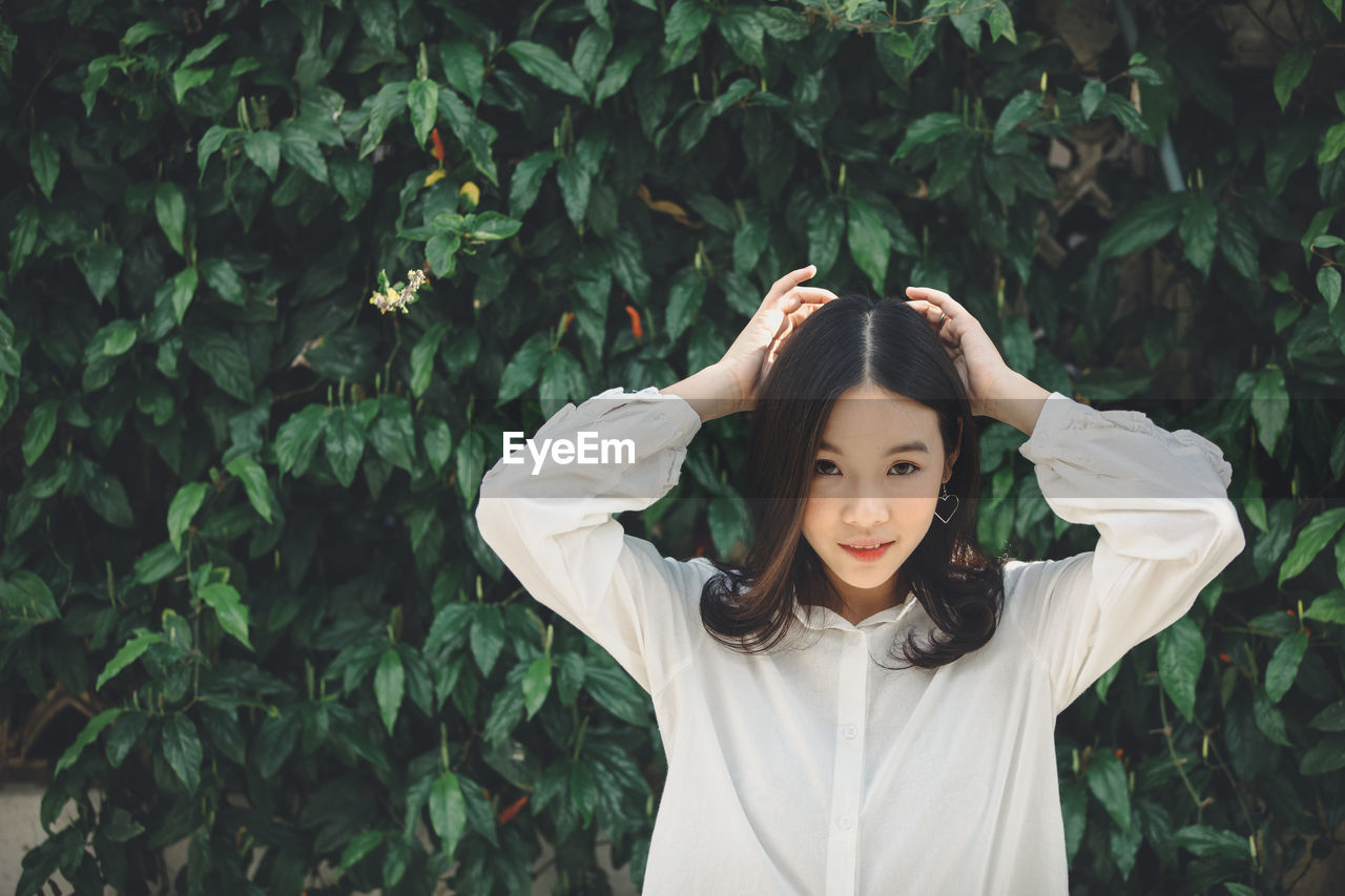 Portrait of young woman standing in park