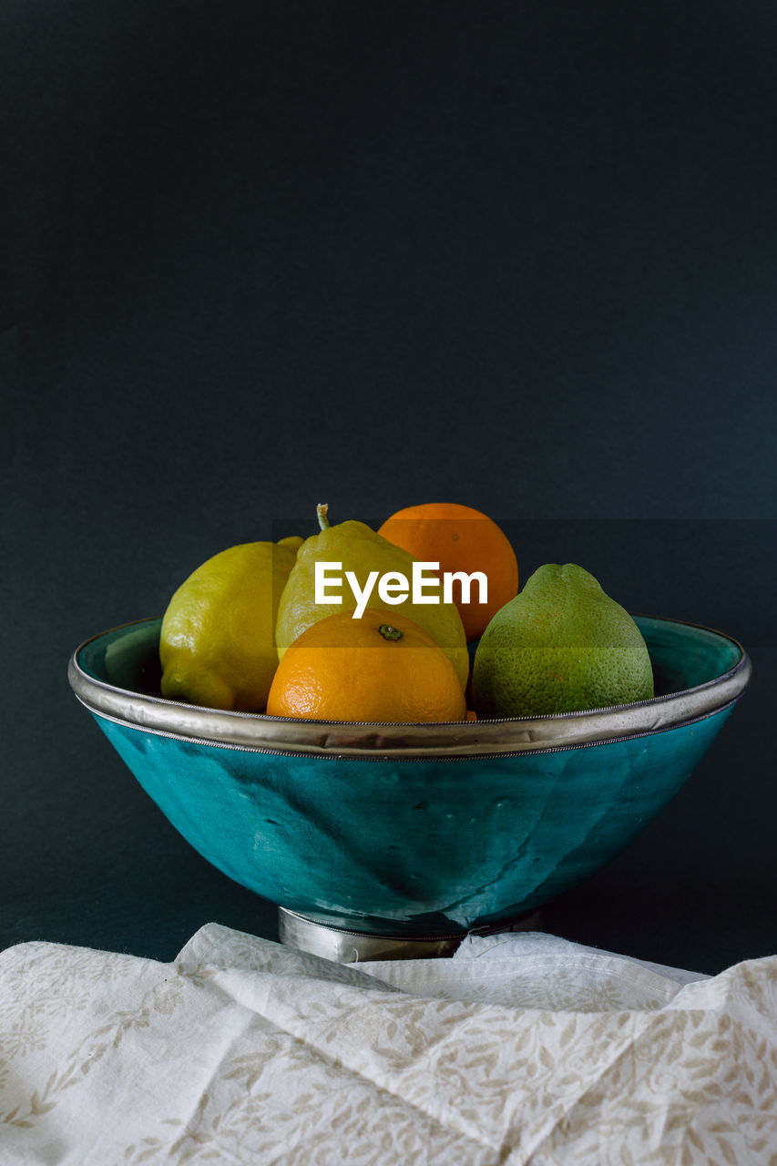 Turquoise bowl of refreshing citrus, orange, lemon and lime.