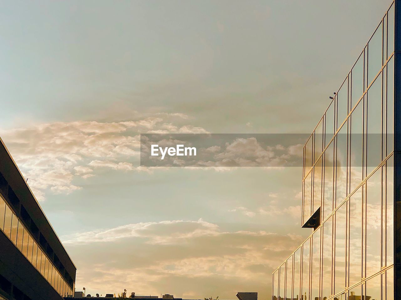 Low angle view of modern buildings against sky during sunset