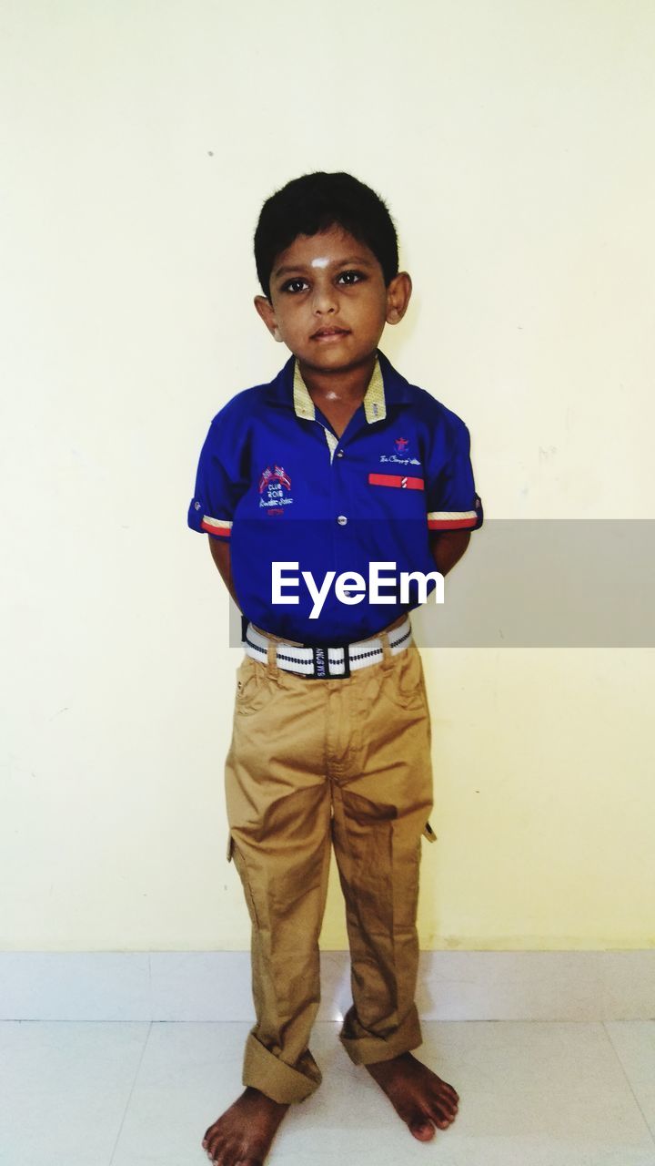 PORTRAIT OF BOY STANDING ON WALL