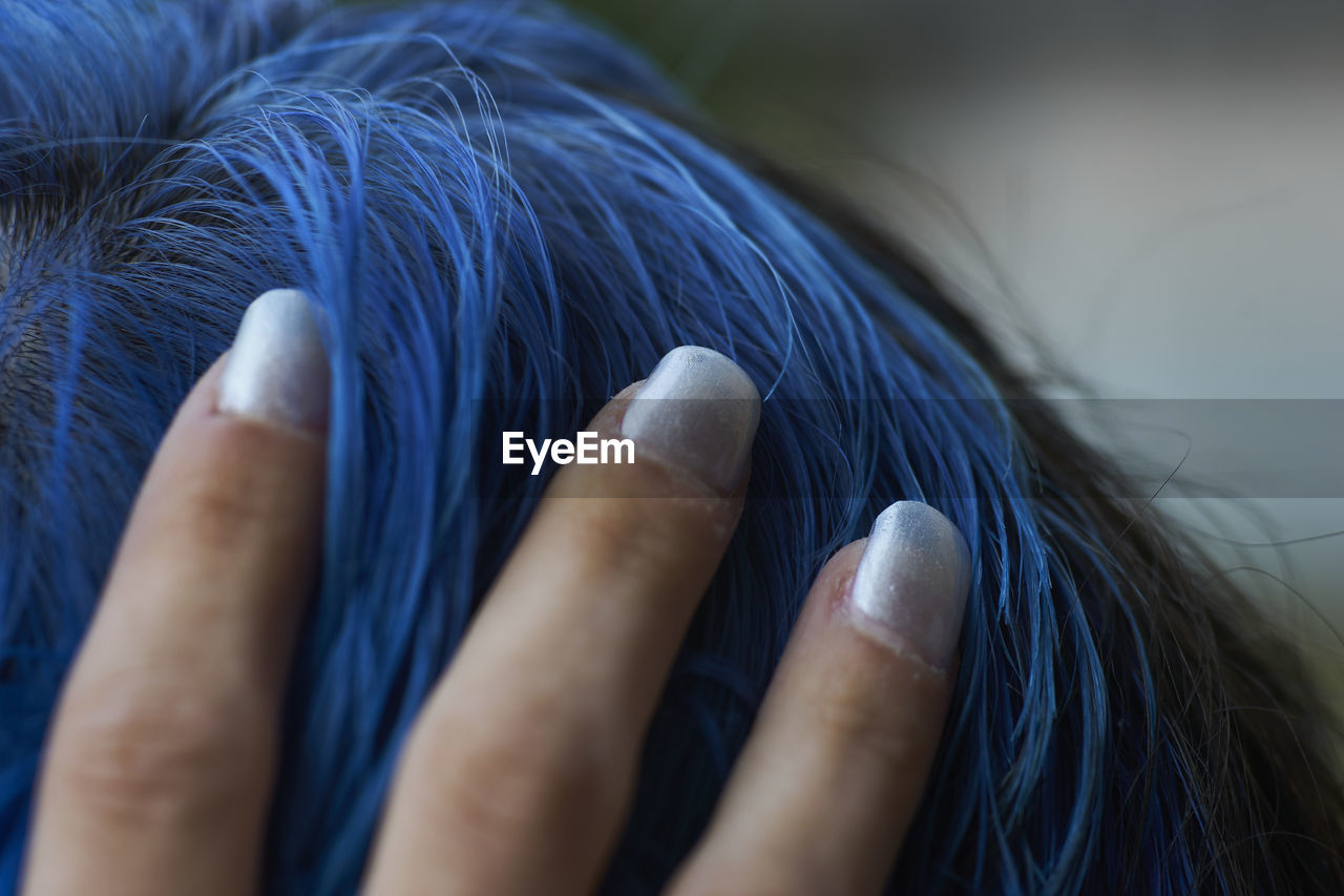 CLOSE-UP OF WOMAN HAND ON BLUE EYES